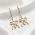 Boucles d'Oreilles Pendantes "Nœud Doré" – Cœur Étincelant