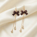 Boucles d’oreilles pendantes nœuds marron et pampilles scintillantes